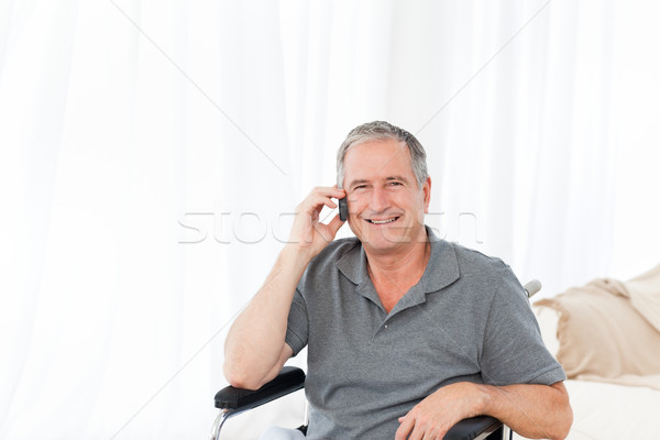 Senior in his wheelchair phoning at home Stock photo © wavebreak_media