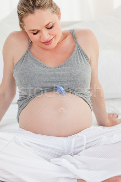 Pregnant woman with a baby dummy on her belly at home Stock photo © wavebreak_media