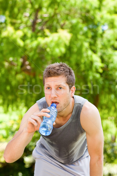 Sporty man drinking water in the park Stock photo © wavebreak_media