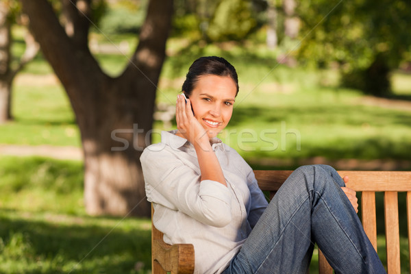 молодые красивая женщина скамейке стороны улыбка лице Сток-фото © wavebreak_media