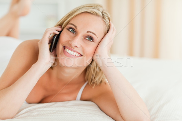 Close up of a smiling woman answering the phone in her bedroom Stock photo © wavebreak_media