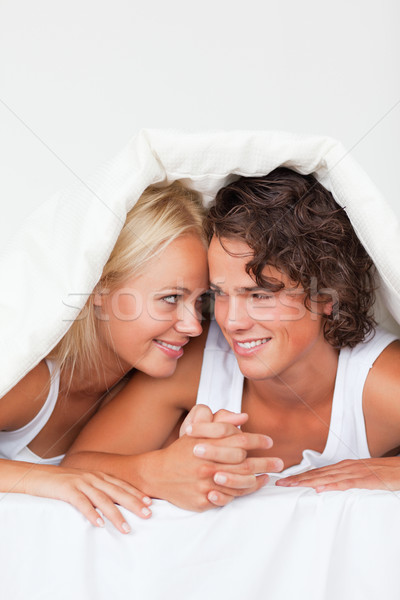 Portrait of a couple looking at each other under a duvet Stock photo © wavebreak_media