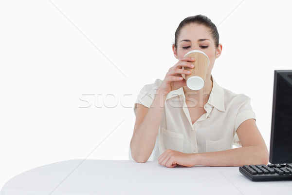 Businesswoman drinking a takeaway tea while using a computer against a white background Stock photo © wavebreak_media