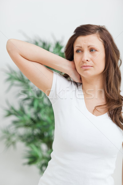 Woman standing while placing her hand on her neck in a room Stock photo © wavebreak_media