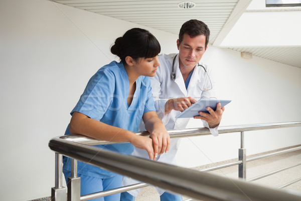 Stock photo: Doctor and nurse talking about exercises in a hallway