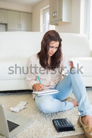 Woman checking bills on the carpet of living room Stock photo © wavebreak_media
