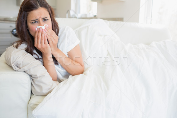Woman with a cold lying on sofa at home Stock photo © wavebreak_media