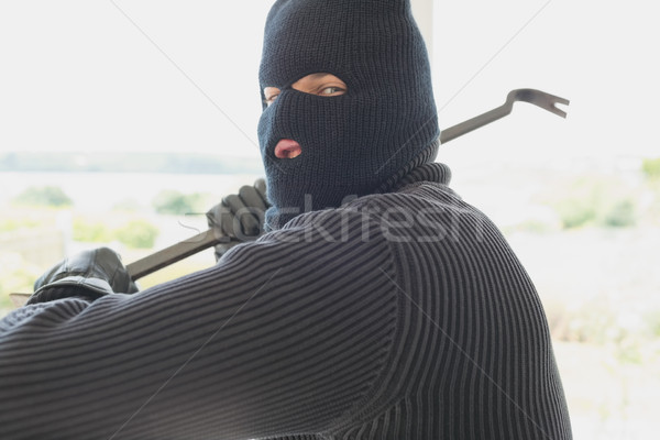 Burglar holding a crowbar and winding up while being in a house Stock photo © wavebreak_media
