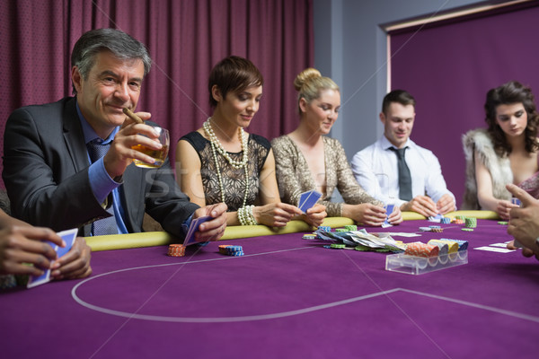 Man with cigar looking up from poker game in casino Stock photo © wavebreak_media