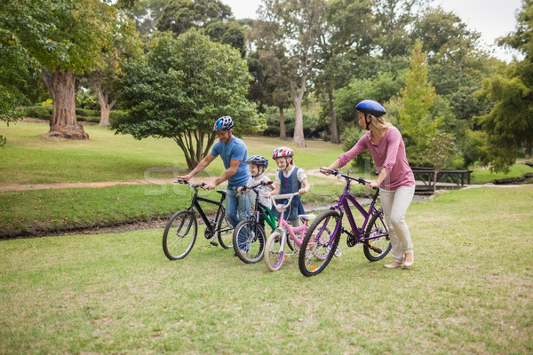 Stock photo: Happy family on their bike at the park 