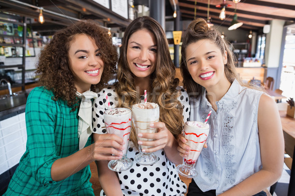 Cheerful female friends posing with drinks in restaurant Stock photo © wavebreak_media