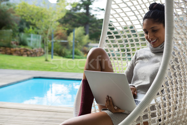 Femme souriante utilisant un ordinateur portable Swing souriant jeune femme eau [[stock_photo]] © wavebreak_media