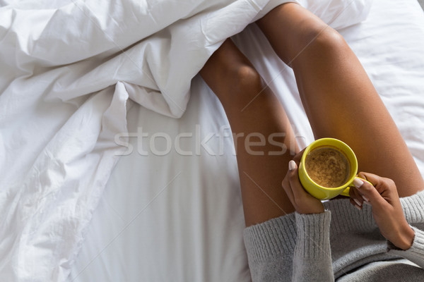 Mulher caneca de café cama relaxante telefone Foto stock © wavebreak_media