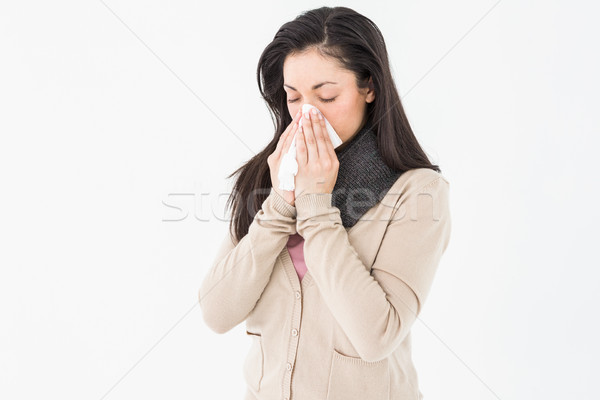 Sick brunette blowing her nose Stock photo © wavebreak_media