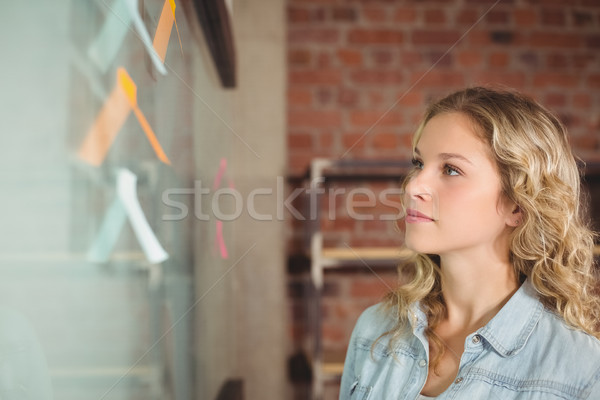 Businesswoman looking at glass board in creative office Stock photo © wavebreak_media