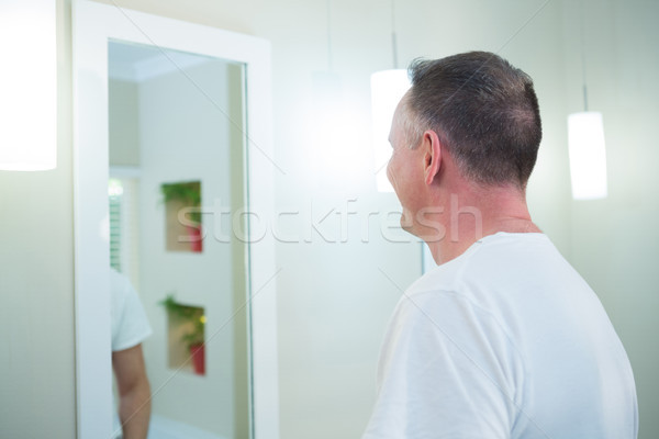 Homme regarder miroir salle de bain vue arrière maison [[stock_photo]] © wavebreak_media