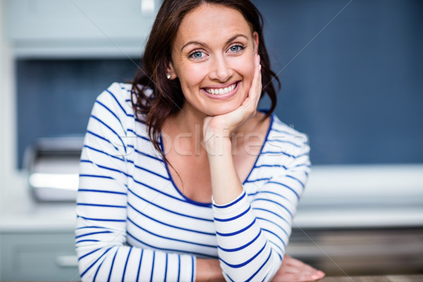 Portrait of happy young woman sitting at table in kitchen Stock photo © wavebreak_media