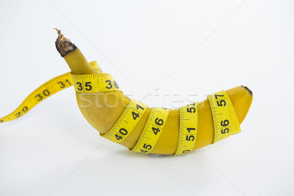 Close-up of fresh banana wrapped with measuring tape Stock photo © wavebreak_media