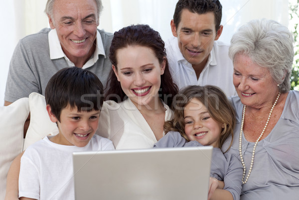 Familia sesión sofá usando la computadora portátil sonriendo ordenador Foto stock © wavebreak_media