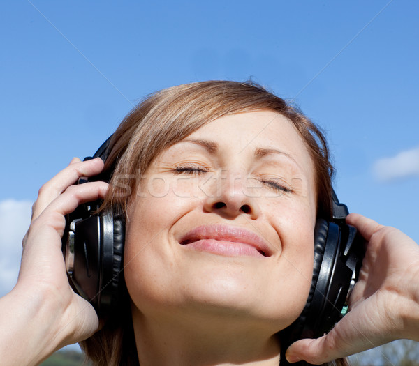 Happy woman is listening music outdoor Stock photo © wavebreak_media