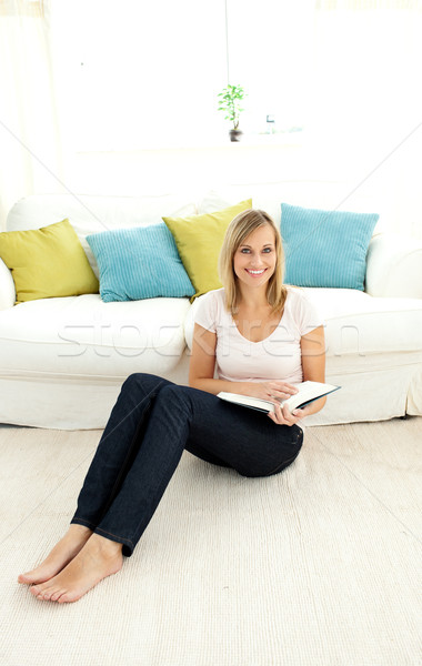 Cute woman reading a book in the living-room Stock photo © wavebreak_media