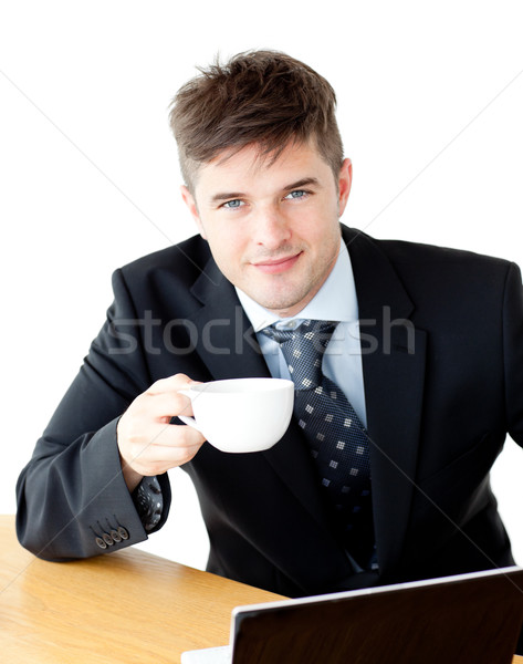 Charming young businessman holding a cup smiling at the camera sitting against white background Stock photo © wavebreak_media