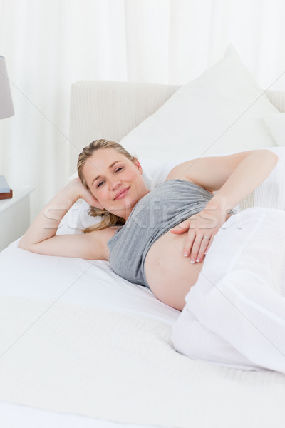 Beautiful woman with her hands on her belly at home Stock photo © wavebreak_media