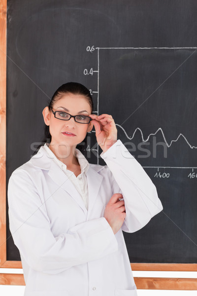 Female scientist standing near the blackboard and looking at the camera Stock photo © wavebreak_media
