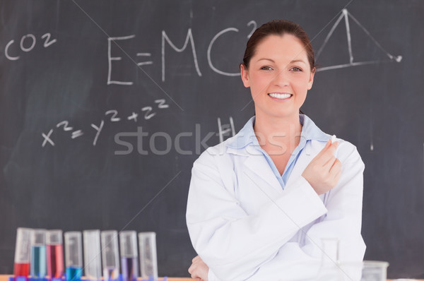 Young scientist holding a piece of chalk while standing in front of a blackboard Stock photo © wavebreak_media