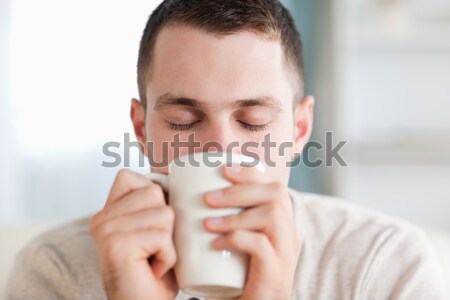 Beautiful female drinking a bowl of coffee in her kitchen Stock photo © wavebreak_media