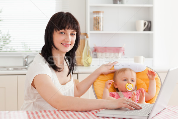 Mooie brunette vrouw ontspannen laptop baby Stockfoto © wavebreak_media