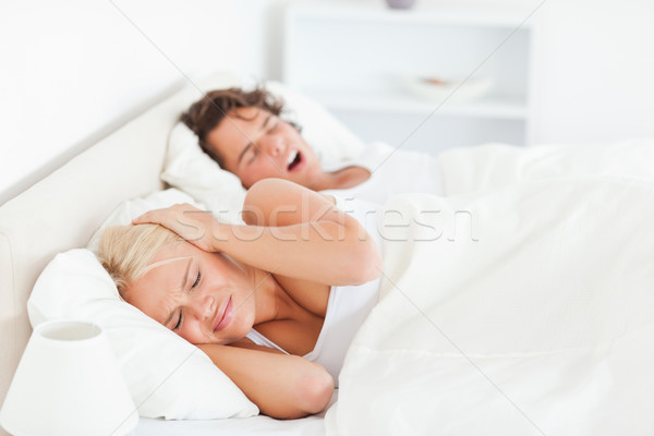 Stock photo: Annoyed woman awaken by her boyfriend's snoring in their bedroom