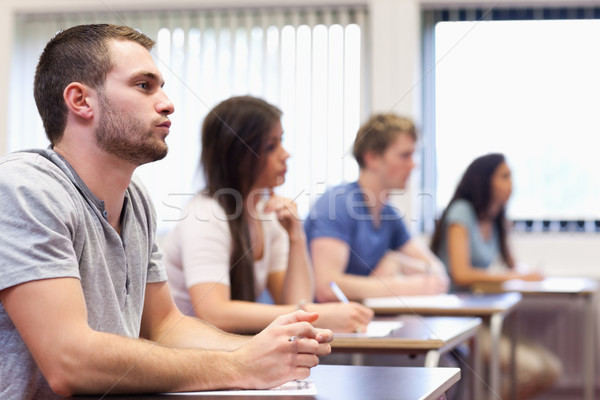 Handsome young man listening in a classroom Stock photo © wavebreak_media