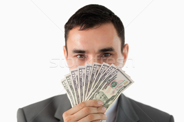 Businessman smelling on banknotes against a white background Stock photo © wavebreak_media