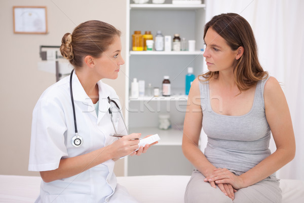 Stock photo: Doctor taking notes while patient is talking