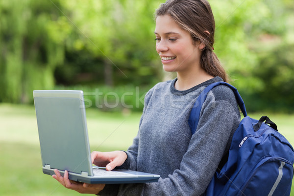 Młodych uśmiechnięta kobieta laptop stałego parku Zdjęcia stock © wavebreak_media