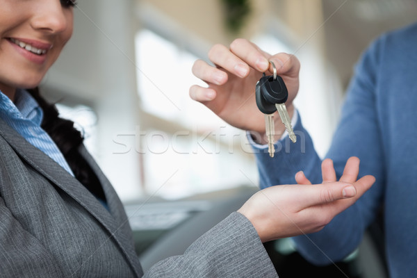 Femeie zambitoare chei mână maşină magazin rutier Imagine de stoc © wavebreak_media