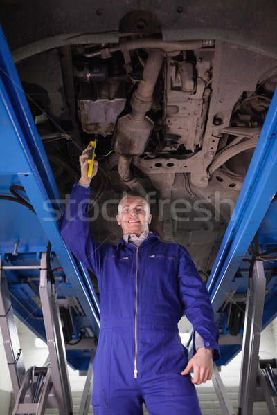 Smiling mechanic repairing a car with an adjustable pliers in a garage Stock photo © wavebreak_media