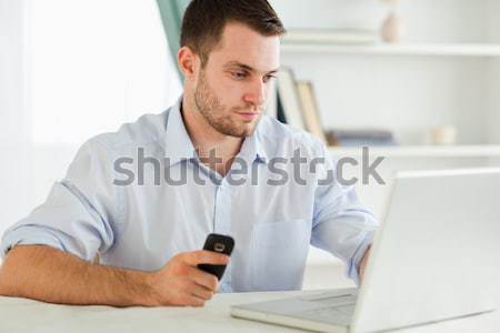 Business woman text messaging in front of laptop Stock photo © wavebreak_media