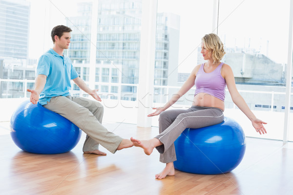 Trainer exercising with pregnant client on exercise balls Stock photo © wavebreak_media