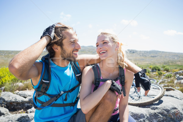 Fit cyclist couple taking a break on rocky peak  Stock photo © wavebreak_media