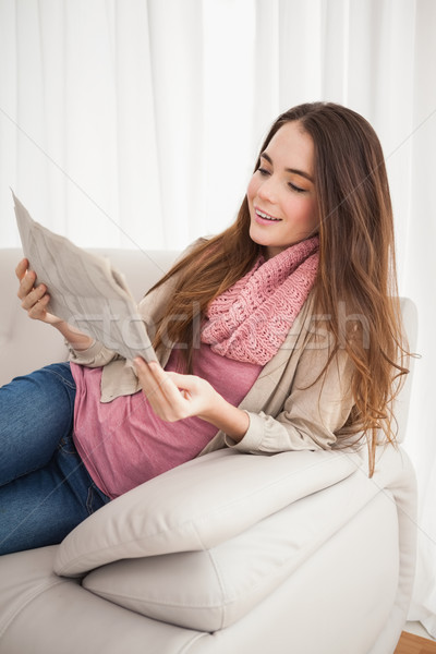 Pretty brunette reading newspaper on couch Stock photo © wavebreak_media