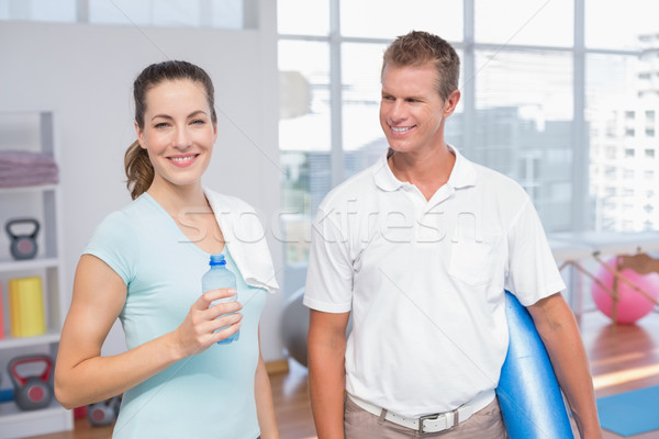 Smiling woman with her trainer looking at camera Stock photo © wavebreak_media