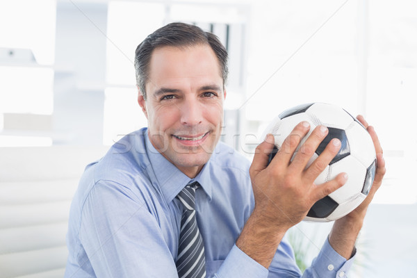 Smiling businessman looking at camera with foot ball  Stock photo © wavebreak_media