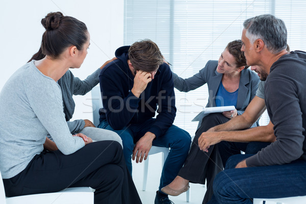 Concerned patients comforting another in rehab group Stock photo © wavebreak_media