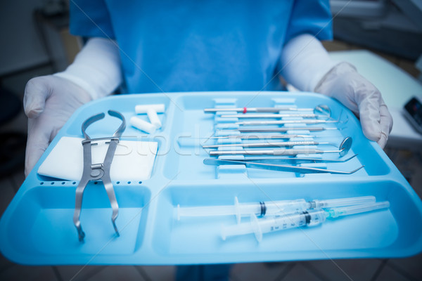 Mid section of dentist in blue scrubs holding tray of tools Stock photo © wavebreak_media