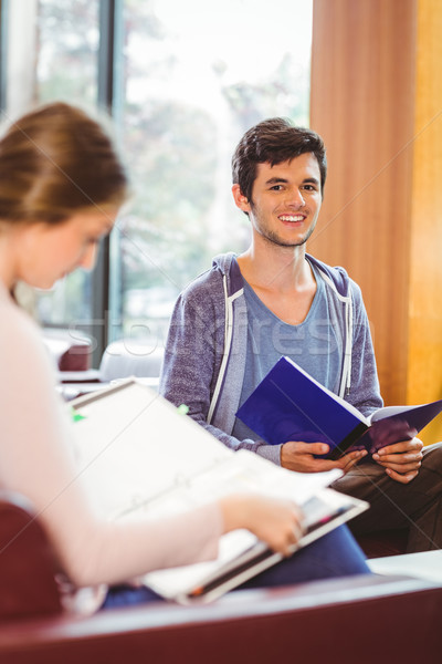 Stock photo: Students sitting on couch revising and smiling at camera