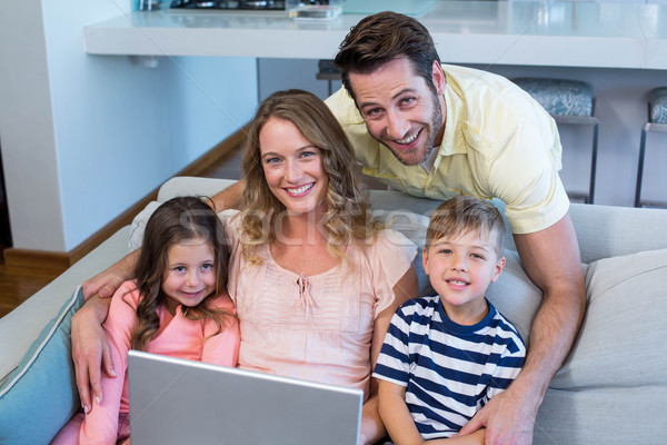 Famille heureuse canapé ensemble utilisant un ordinateur portable maison salon [[stock_photo]] © wavebreak_media