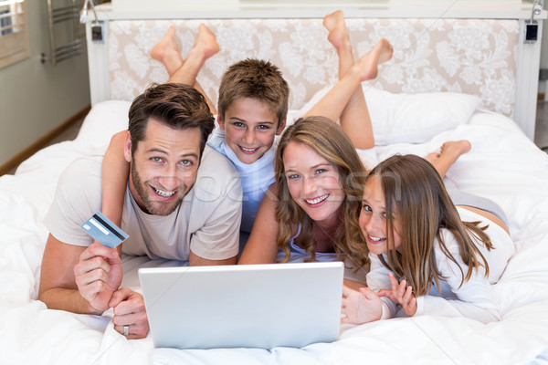 Famille heureuse lit utilisant un ordinateur portable maison chambre ordinateur [[stock_photo]] © wavebreak_media