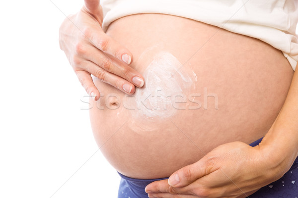 Pregnant woman with cream on bump Stock photo © wavebreak_media